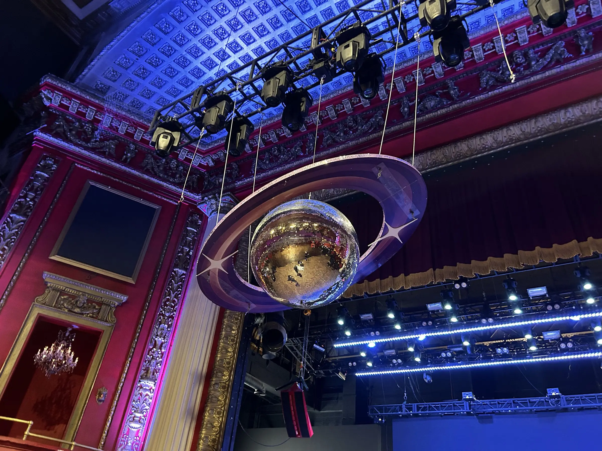 The same ring rig beside the gilded box seats and the painted proscenium of the theatre.