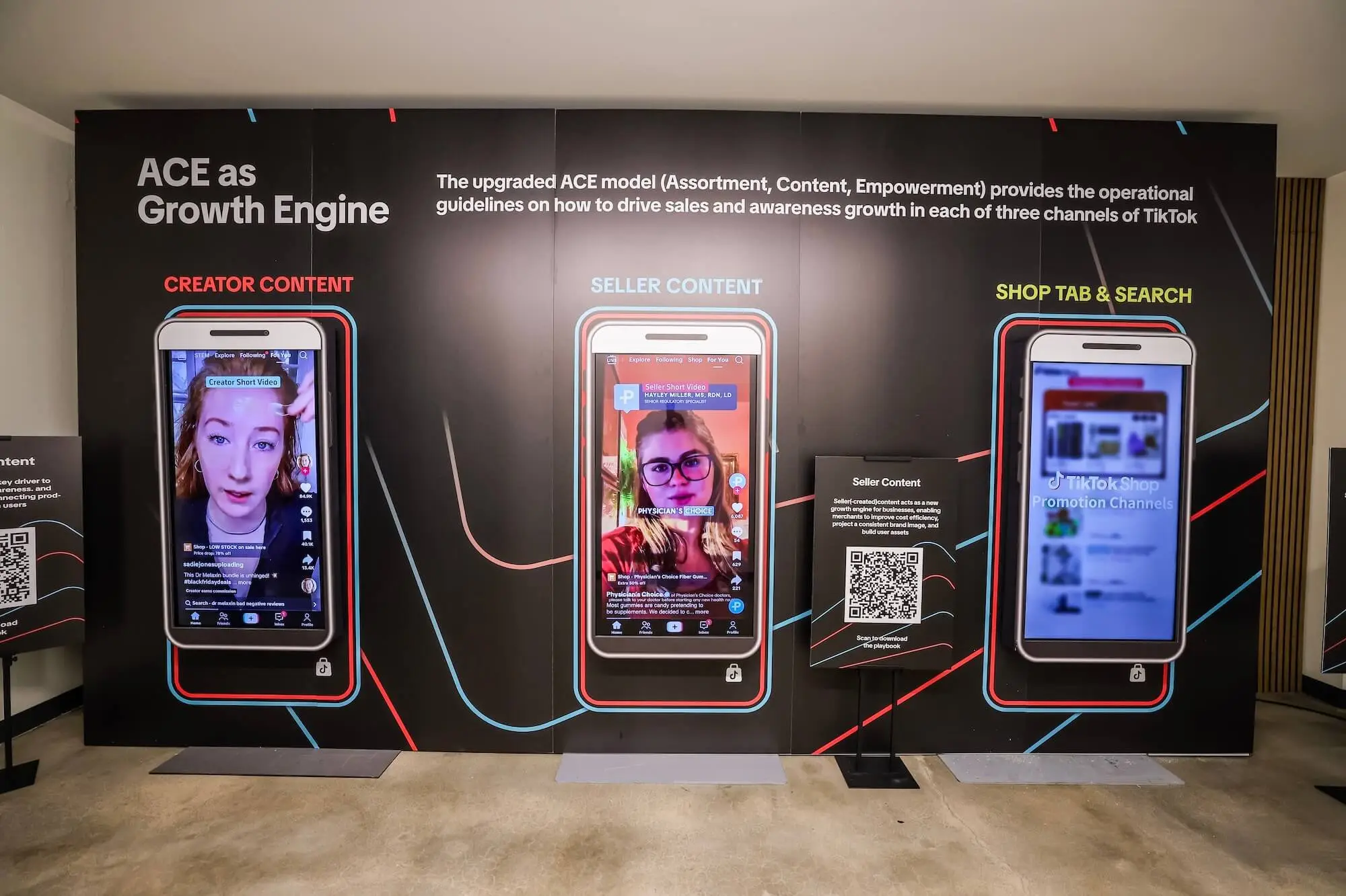 A backlit wall set piece with three oversized phone frames, each running a different app screen under the heading ACE as Growth Engine.